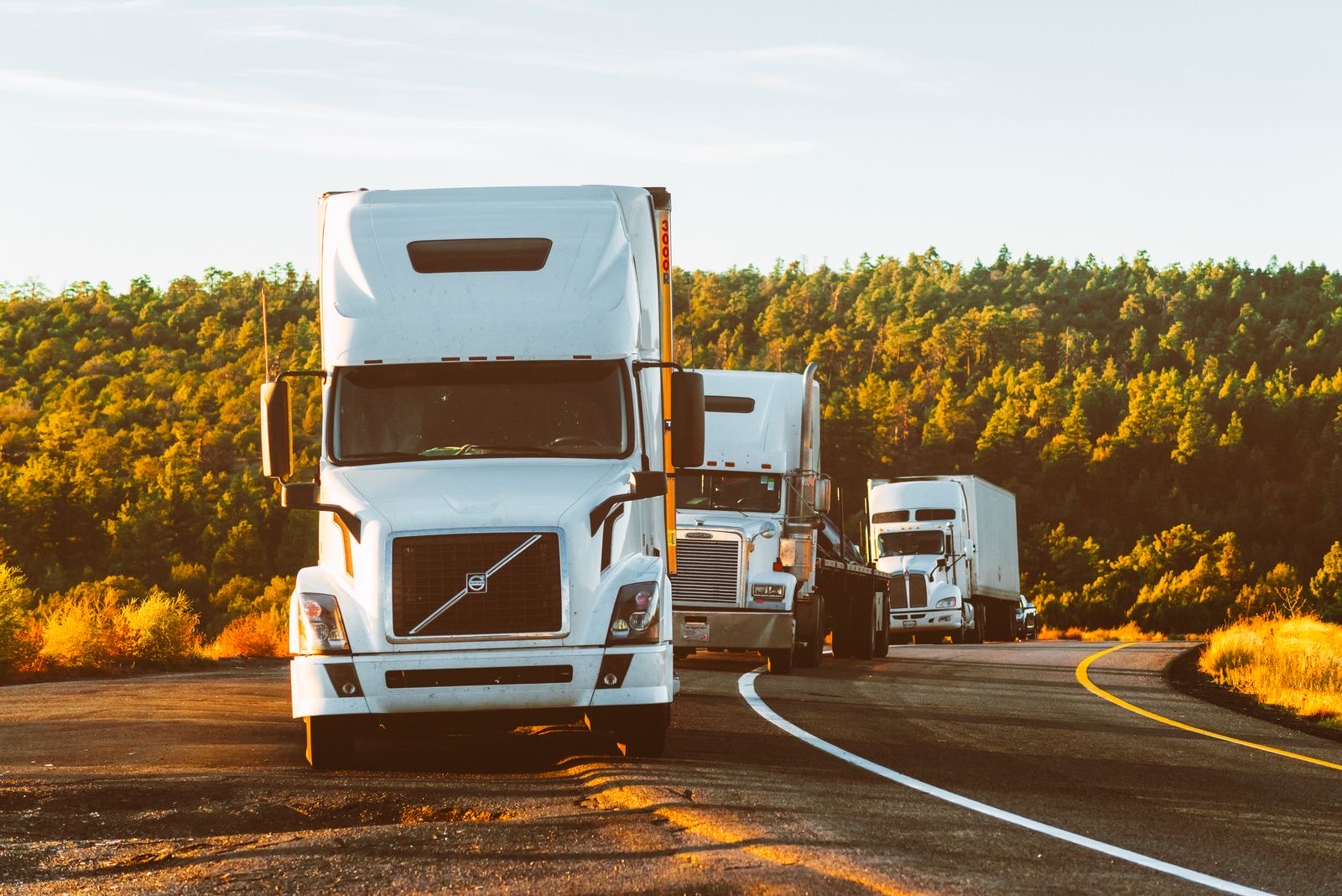 Drayage trucks on the road at sunset
