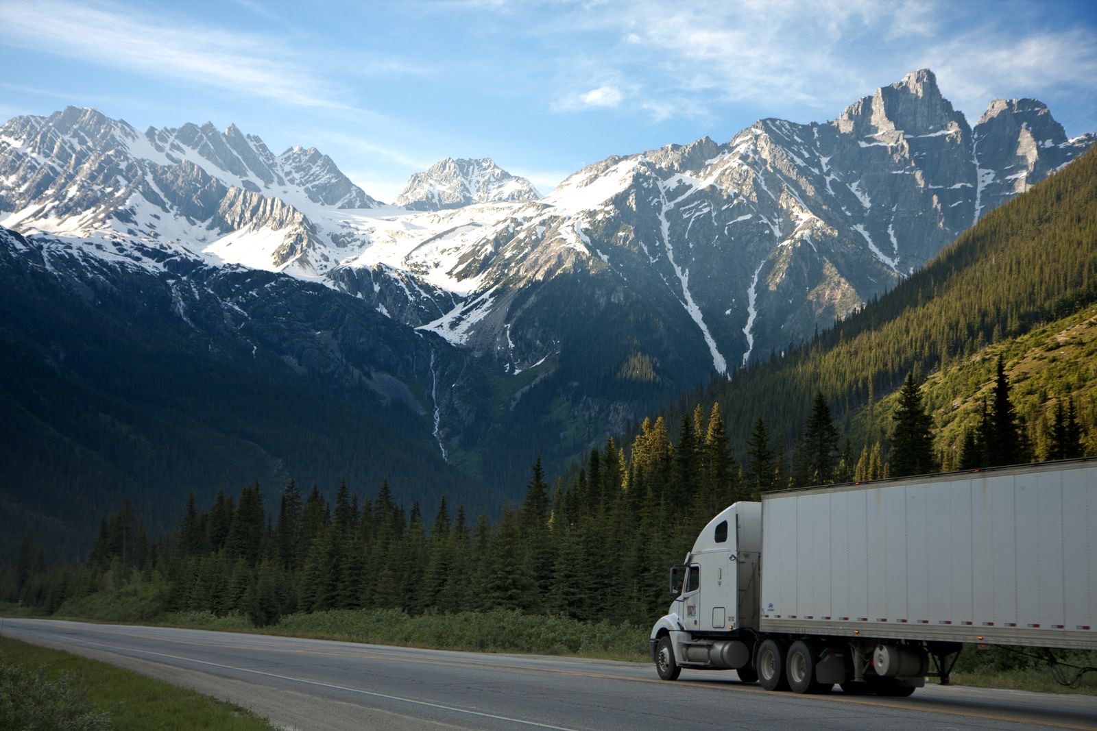 Semi truck hauling freight on a Pacific Northwest highway